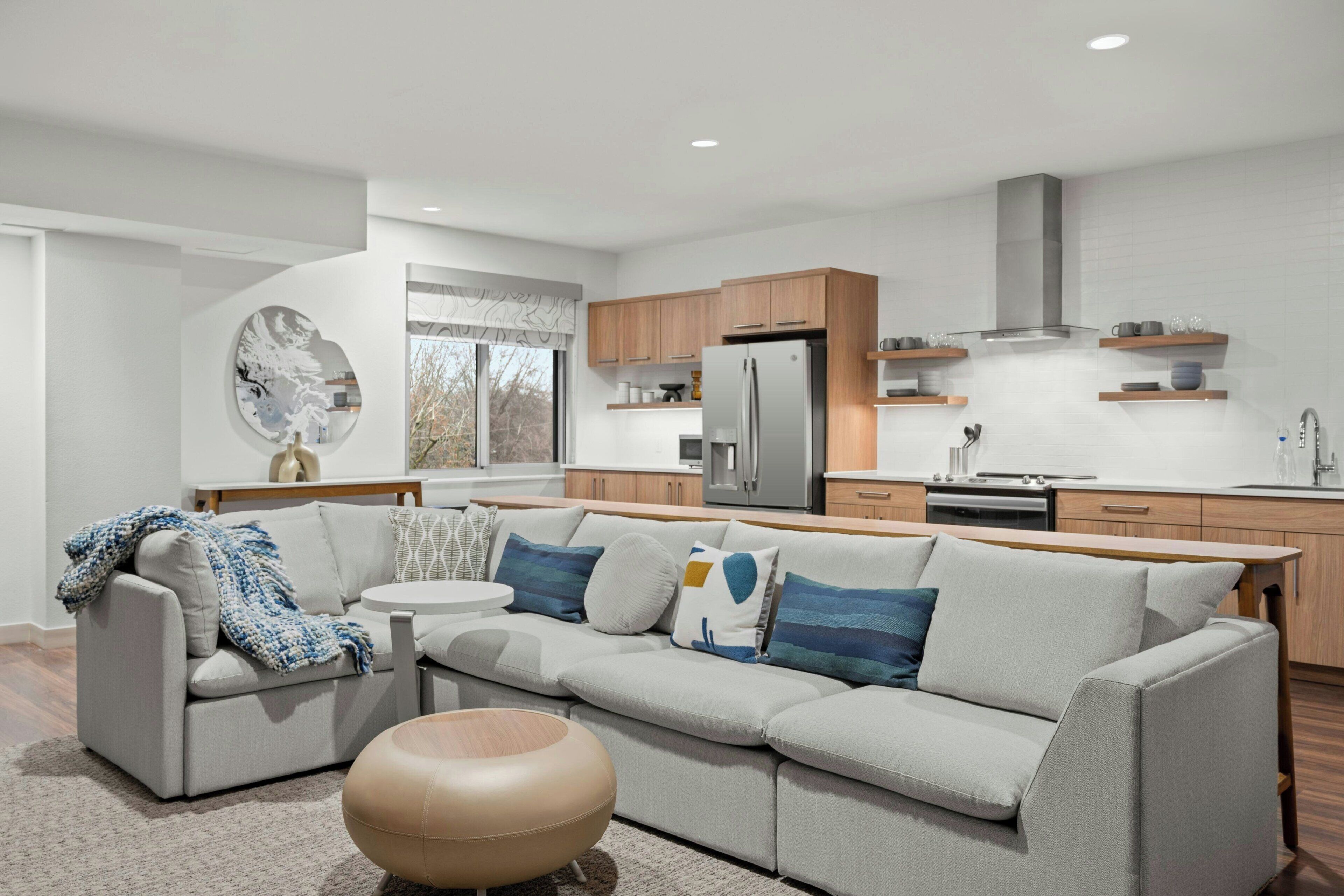 A modern kitchen with a built-in refrigerator, wooden cabinets, and a stainless steel range hood.