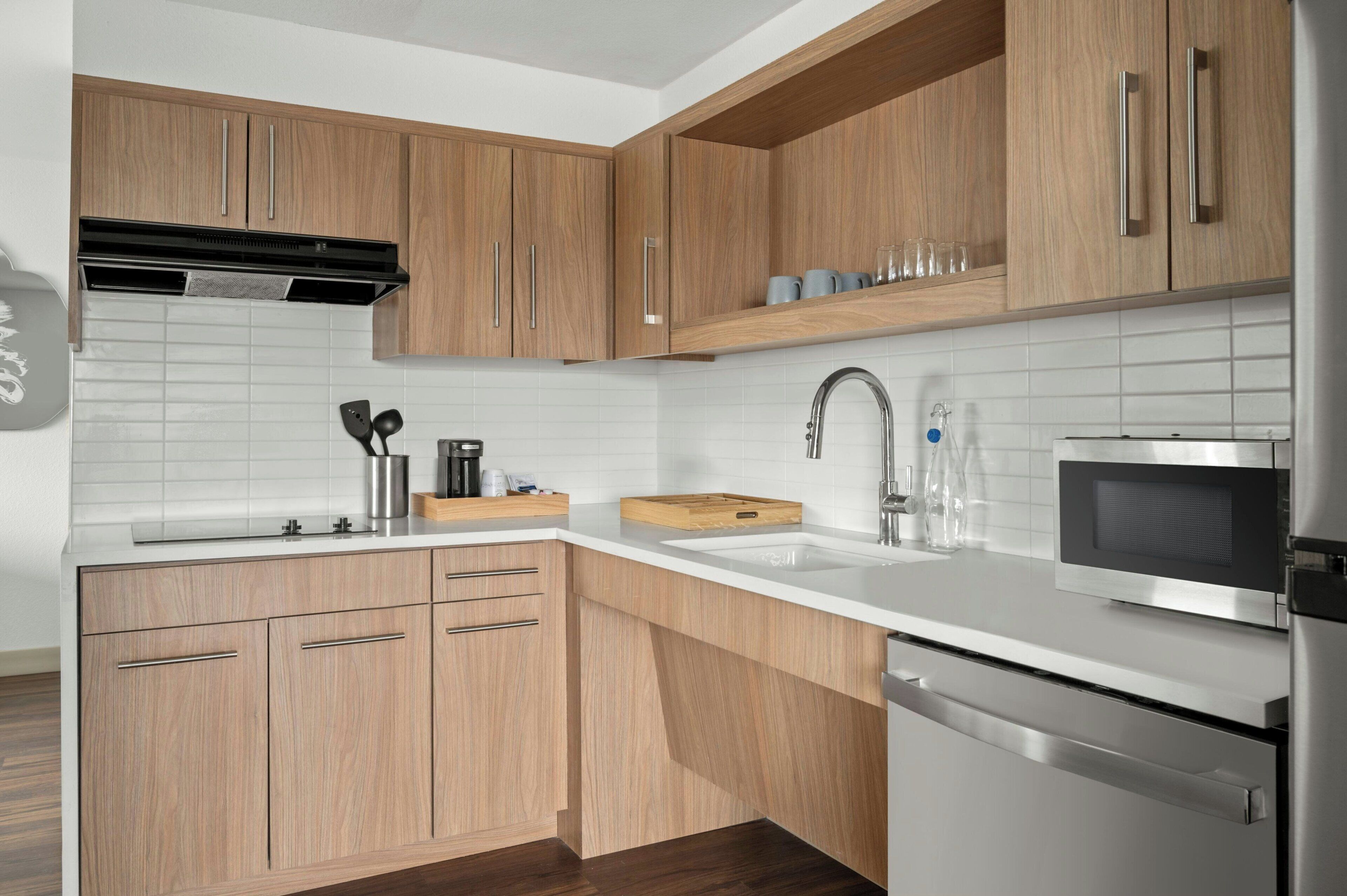 Una cocina moderna con armarios de madera, un refrigerador de acero inoxidable y un microondas.