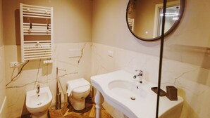 A bathroom with a bidet, toilet, sink, and mirror. - GuestHost - Chiara Comfy Apartment D (Udine)
