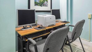 A workspace with two monitors, a printer, a keyboard, a mouse, and a chair.