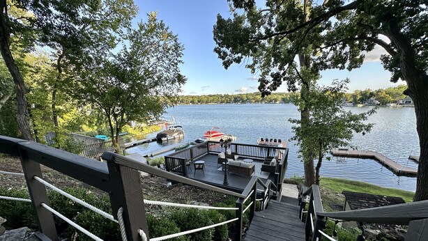 A wooden deck with a view of a lake and dock area.