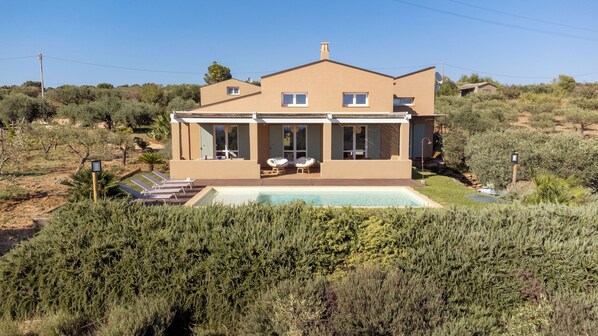 A two-story house with a swimming pool, surrounded by dense shrubbery and trees. - Baglio di Verre (Menfi)