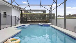 Piscina com área coberta, cercada por uma grade e vista para o bairro.