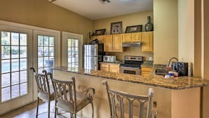 A kitchen with a granite countertop, stainless steel appliances, and wooden cabinets. - Clearwater Condo w/Pool Access, 4Mi to Beach! (Clearwater)