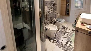 A modern bathroom with a glass shower enclosure, a toilet, and a sink area. - Roman Holidays (Roma)
