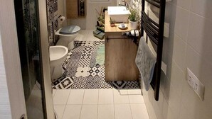 A compact bathroom with a toilet, sink, and shower area. - Roman Holidays (Roma)