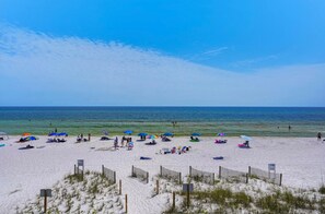Relax on the sandy shore, surrounded by beach umbrellas and sun loungers.