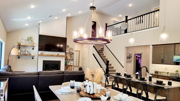 A modern kitchen with a dining area, a staircase, and a living room with a sofa. - Posh Pelican House is guest favorite in quaint resort town of Breezy Point! (Breezy Point)