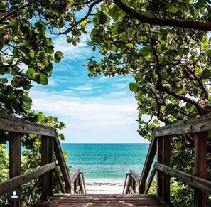 Eine Holztreppe führt zu einem Strand mit freiem Blick auf den Ozean.