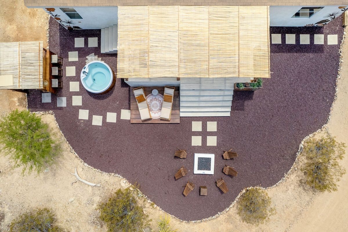 An aerial view of a property with a swimming pool, outdoor seating area, and a covered patio.