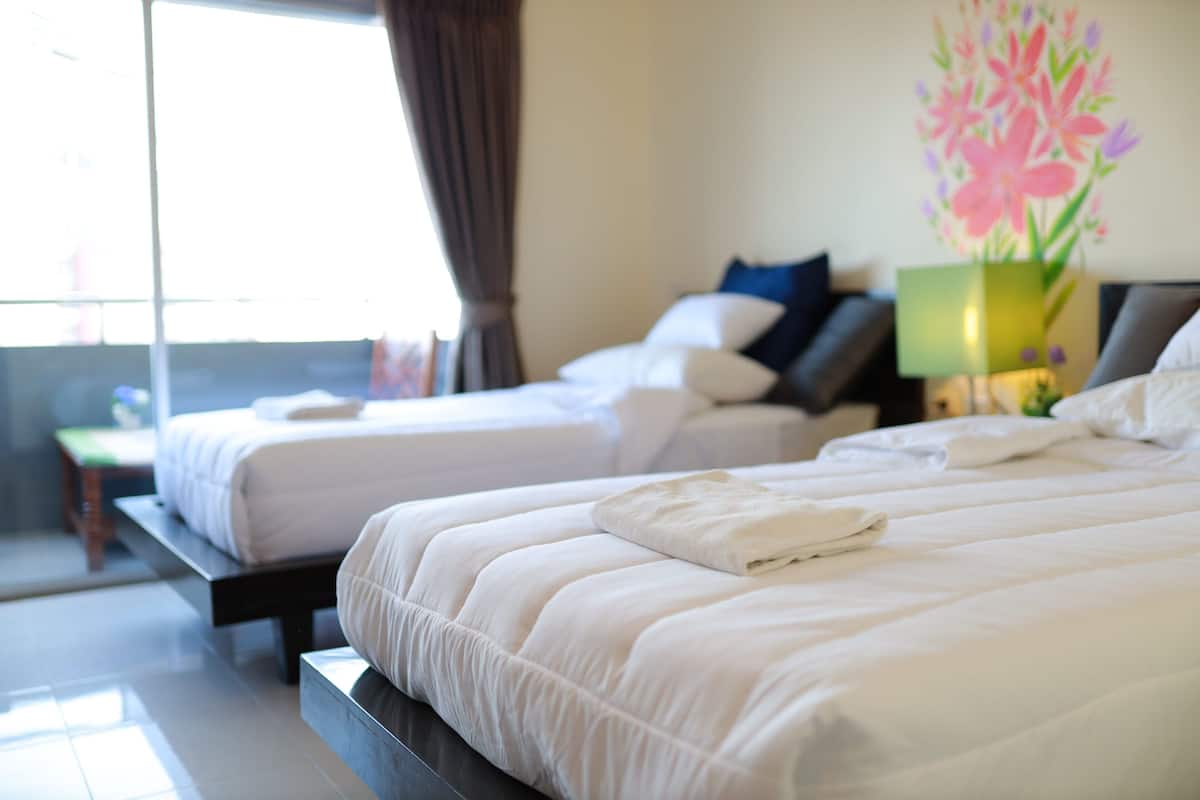 Une chambre d’hôtel avec deux lits, une table de chevet, une lampe et un tableau au mur.