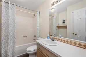 A bathroom with a bathtub, toilet, and sink.