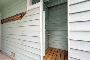 Un espacio pequeño y cerrado con suelo de madera, una puerta de metal y un objeto de madera en la pared.