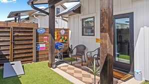 A residential property with a covered patio, a wooden fence, and outdoor seating.