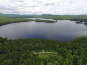 A large lake surrounded by dense forest, with a small island in the center.