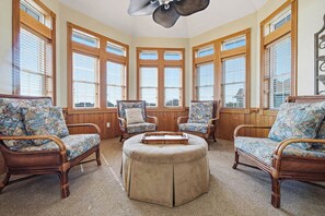 A room with large windows, wicker furniture, and a ceiling fan. - Pair-a-dice | 1400 ft to the beach | Private Pool and Hot Tub (Corolla)