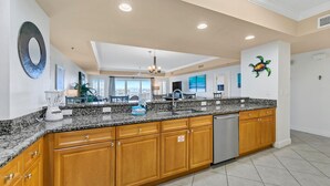 A spacious kitchen with granite countertops, wooden cabinets, and a dishwasher.
