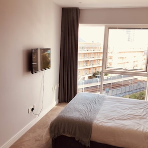 Relax in comfort with a large bed and a flat-screen TV, plus a balcony view of the city.