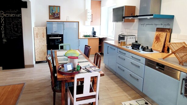 Eine moderne Küche mit hellblauen Schränken, einem Holzespeisetisch und einer Tafel mit Schrift.