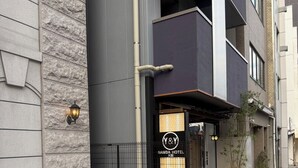 A modern hotel entrance with a stone facade, a black metal fence, and a sign for 'Namba Hotel'. - Y&Y NAMBA HOTEL Osaka (Osaka)