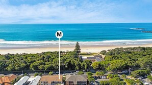 Zona costera con playa, aparcamiento y edificios.