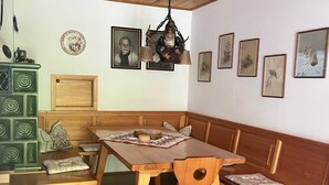 Een houten eethoek met een bank, een tafel en een hanglamp.