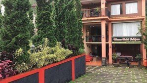 A two-story building with a sign reading "Wisma Bulut Sekipan" and a balcony with a table and chairs. - Red Chilies Hill Hotel (Tawangmangu)