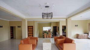 A spacious lobby with two leather sofas, a marble coffee table, and a decorative ceiling light. - Red Chilies Hill Hotel (Tawangmangu)