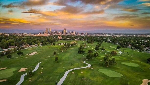 An aerial view of a golf course with a city skyline in the background. - Walk to Music, Cafe, Bars, Food & Hospital in Central Denver. Turo + 420 ok!  (Denver)