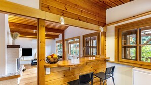 Un intérieur en bois comprenant un espace cuisine, un comptoir de bar et des sièges.