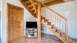 Una escalera de madera con un mueble para televisión en el centro.