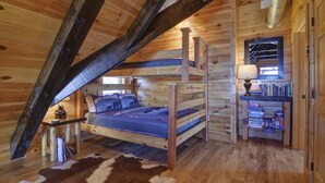 A cozy cabin with a loft bed, a small desk, and a bookshelf. - Mountain Cabin, Hot Tub, Fire Pit, Views, Outdoor Bar, Stocked Kitchen (Bryson City)