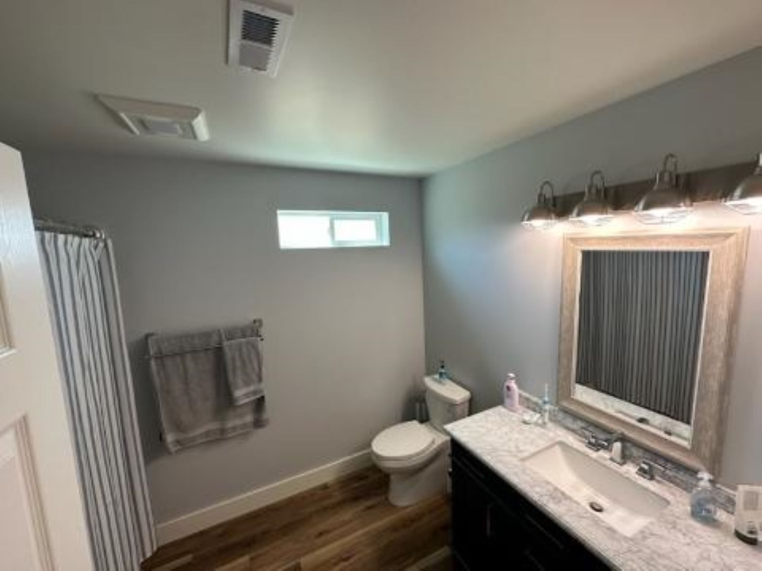 A bathroom with a toilet, sink, and shower.