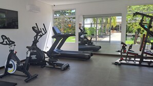 Una palestra con cyclette, tapis roulant e macchinari per pesi.
