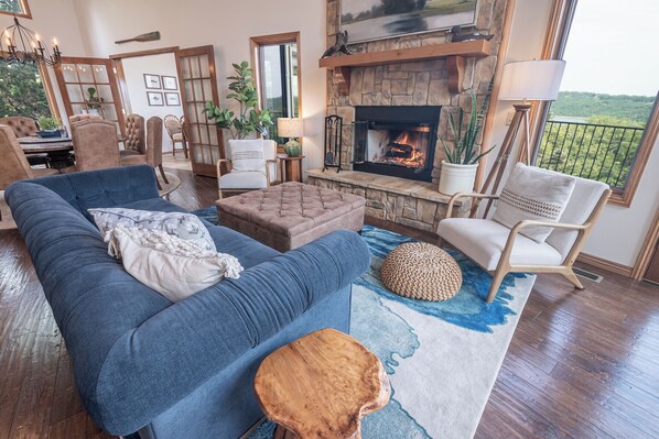 Un salón acogedor con chimenea, asientos cómodos y vistas al exterior.