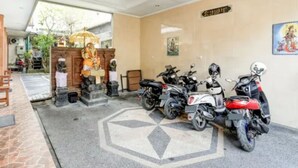 A room with a shrine, a prayer wheel, and several parked motorcycles. - Antara Sunset Road (Denpasar)