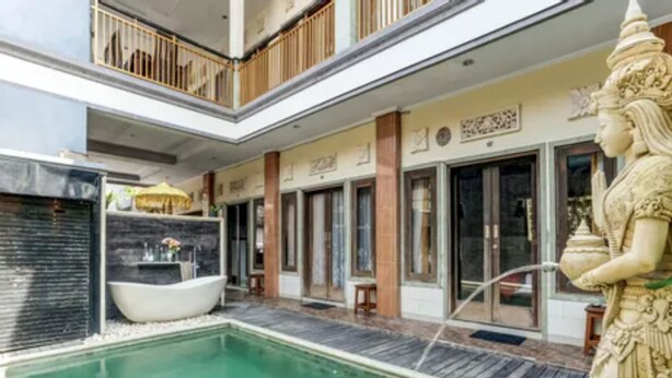 A spa area with a large pool, a hot tub, and a statue. - Antara Sunset Road (Denpasar)