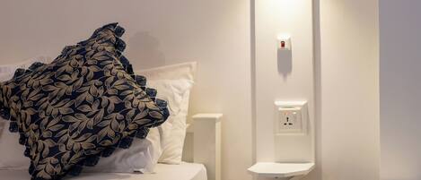 Ein Hotelzimmer mit Bett, Nachttisch und Beistelltisch.