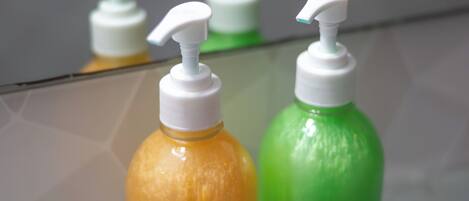 Two bottles of body wash on a reflective surface.