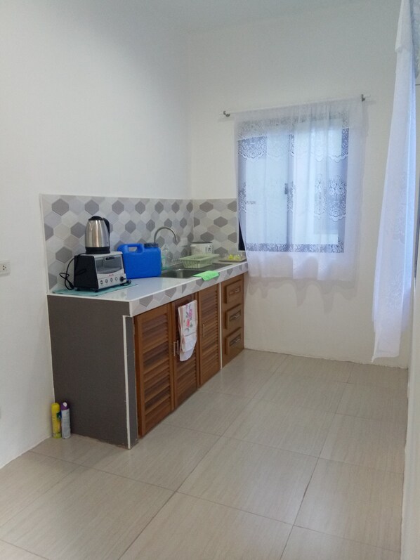 Una cocina compacta con tostadora, hervidor y pileta.