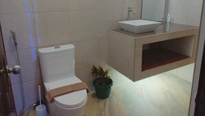 Ein modernes Badezimmer mit Toilette, Waschbecken und Dusche.