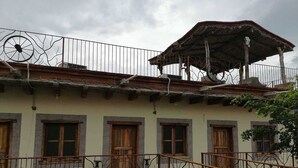 A building with a balcony, wooden doors, and a metal railing.