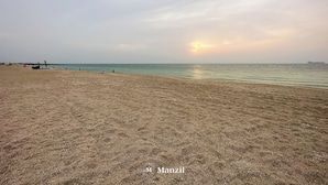 A beach with a pier and calm sea. - Manzil - 1BR | Near La Mer Beach | Pool & Sea View (Dubai)