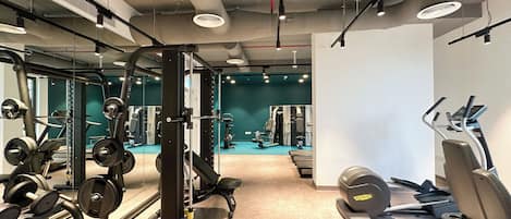 A gym with weightlifting equipment, treadmills, and exercise machines.