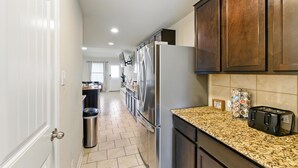 A kitchen with stainless steel appliances, granite countertops, and wooden cabinets. - Gorgeous 5-bedroom home in Schertz, San Antonio, New Braunfels (Schertz)