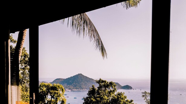 A view from a room with a stone patio and a pool, overlooking a body of water and distant islands. - Lunar Villas Koh Tao - Luxury Pool Villa (Koh Tao)