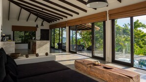 A modern interior with a kitchen, seating area, and large windows offering a view of the outdoors. - Lunar Villas Koh Tao - Luxury Pool Villa (Koh Tao)
