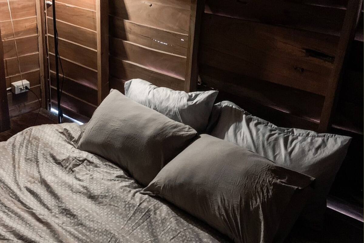 Un lit avec une couvre-lit à motifs et deux oreillers.
