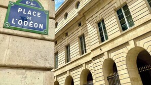 A building facade with a sign reading "Place de L'Odéon".