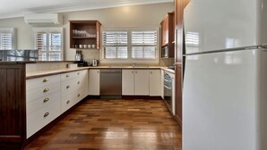 Une cuisine avec des meubles en bois, un réfrigérateur blanc et un lave-vaisselle.